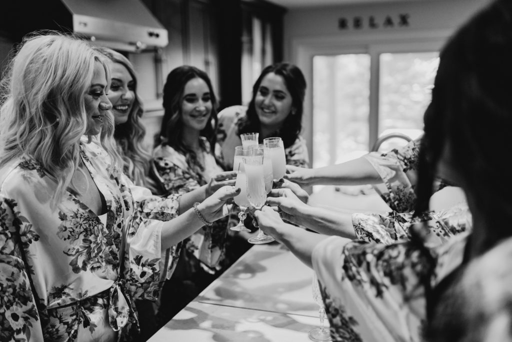 bridesmaids cheers for bride on morning of wedding day in toronto, ontario