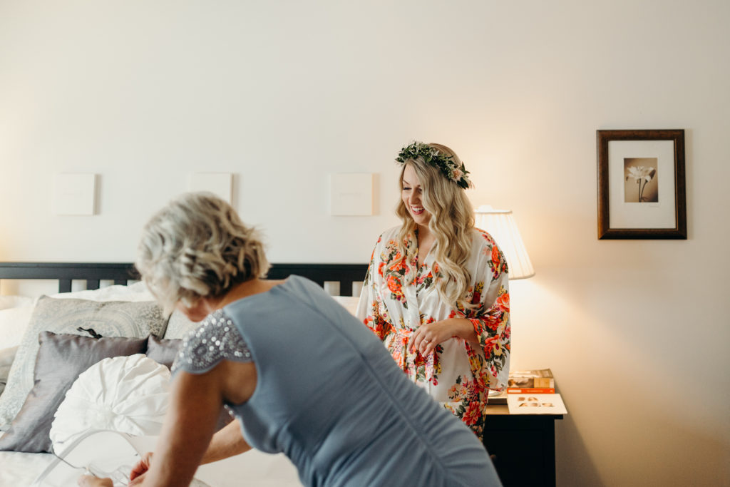 bride getting ready on morning of wedding with flower crown